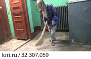 A young woman in blue jeans and a cage shirt swings and washes the floor on a staircase next to an elevator in a Stalinist-built apartment building, Cleaning public spaces by a labor immigrant cleane. Стоковое видео, видеограф Куликов Константин / Фотобанк Лори