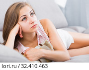 Disappointed girl lying on couch with cushion. Стоковое фото, фотограф Яков Филимонов / Фотобанк Лори