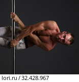 Studio image of male dancer exercising on pole. Стоковое фото, фотограф Гурьянов Андрей / Фотобанк Лори