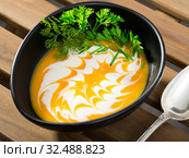 Recipe of pumpkin soup puree with ginger root - roast pumpkin in olive oil, beat in blender with vegetable broth. Add whisked cream with garlic and ginger. Serve with greens. Стоковое фото, фотограф Яков Филимонов / Фотобанк Лори