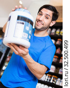 Athletic man seller demostration sport nutrition products in shop. Стоковое фото, фотограф Яков Филимонов / Фотобанк Лори