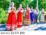 Russia, Samara, June 2017: smart girls in national clothes sing for city residents on the embankment of the Volga River on a sunny summer day. Редакционное фото, фотограф Акиньшин Владимир / Фотобанк Лори