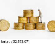 Маленький человечек в униформе складирует свои накопления. Успешный бизнес. Стоковое фото, фотограф Элина Гаревская / Фотобанк Лори