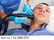 Female specialist is massaging with vacuum to face of client for anti-aging. Стоковое фото, фотограф Яков Филимонов / Фотобанк Лори