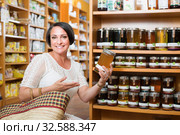 Mature woman customer holding honey jar. Стоковое фото, фотограф Яков Филимонов / Фотобанк Лори