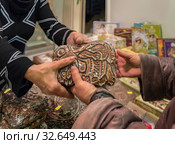 Продажа традиционных тульских пряников. Продавец передает вкусный пряник в руки покупателя. (2019 год). Редакционное фото, фотограф Светлана Васильева / Фотобанк Лори