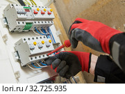 Electrician works with switchbox. installing circuit breaker. Стоковое фото, фотограф Дмитрий Калиновский / Фотобанк Лори