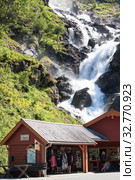 Local tourist center and souvenir shop is near Latefoss waterfall on Norwegian National Road 13. Latefossen fall consists of two separate streams flowing down. Odda, Hordaland, Norway (2018 год). Редакционное фото, фотограф Кекяляйнен Андрей / Фотобанк Лори