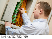 Electrician works with fiber optic cables in switchbox. Стоковое фото, фотограф Дмитрий Калиновский / Фотобанк Лори