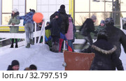 Дети катаются с ледяной горки на городской площади. Children ride on an ice slide in the town square. Стоковое видео, видеограф Евгений Романов / Фотобанк Лори