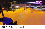 Дети катаются с ледяной горки на городской площади. Children ride on an ice slide in the town square. (2019 год). Редакционное видео, видеограф Евгений Романов / Фотобанк Лори