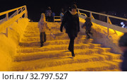 Дети катаются с ледяной горки на городской площади. Children ride on an ice slide in the town square. (2019 год). Редакционное видео, видеограф Евгений Романов / Фотобанк Лори