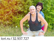 Mature beautiful couple in love on a green lawn in a park on a summer sunny day. Стоковое фото, фотограф Акиньшин Владимир / Фотобанк Лори