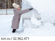 Женщина сметает снег с теплицы. Стоковое фото, фотограф Кекяляйнен Андрей / Фотобанк Лори