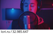 A man rapping through the pop-filter in the microphone - recording his track in the studio. Стоковое видео, видеограф Константин Шишкин / Фотобанк Лори