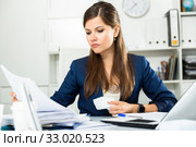 Tired young businesswoman working with documents in office. Стоковое фото, фотограф Яков Филимонов / Фотобанк Лори