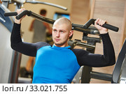 male doing excercise on training machine in gym. Стоковое фото, фотограф Дмитрий Калиновский / Фотобанк Лори