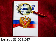Брошюра "Конституция Российской Федерации" под лупой на красном фоне (2020 год). Редакционное фото, фотограф Николай Винокуров / Фотобанк Лори