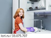 teenager girl in purple rubber gloves washes dishes in kitchen. Стоковое фото, фотограф Майя Крученкова / Фотобанк Лори