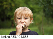 Blond  boy eating cake outdoors. Стоковое фото, фотограф Jaroslav Frank / PantherMedia / Фотобанк Лори
