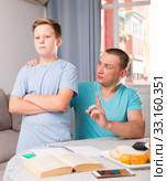 Man is offended and son is not wanting talking with him in time doing homework. Стоковое фото, фотограф Яков Филимонов / Фотобанк Лори
