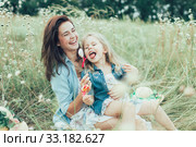 The young mother and daughter on green grass background. Стоковое фото, фотограф Volodymyr Melnyk / PantherMedia / Фотобанк Лори