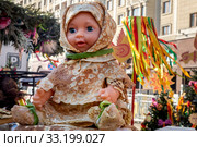 Детская кукла одетая в блины на площадке ярмарки на площади Революции города Москвы во время празднования Масленицы, Россия (2020 год). Редакционное фото, фотограф Николай Винокуров / Фотобанк Лори