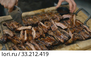 Waiter cuts fried pork ribs. Стоковое видео, видеограф Kozub Vasyl / Фотобанк Лори