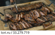 Waiter cuts fried pork ribs. Стоковое видео, видеограф Kozub Vasyl / Фотобанк Лори