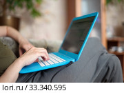 Руки женщины на клавиатуре ноутбука, который лежит на коленях в комнате. Стоковое фото, фотограф Светлана Попова / Фотобанк Лори