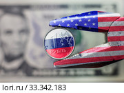 New Sanctions against the Russian economy. Pliers with USA flag squeezed the ruble with Russian flag. Стоковое фото, фотограф Evgenii Mitroshin / Фотобанк Лори