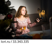 Happy young woman watching TV on Christmas night. Стоковое фото, фотограф Яков Филимонов / Фотобанк Лори