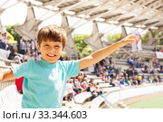 Happy little boy waving hand on stadium and smile. Стоковое фото, фотограф Сергей Новиков / Фотобанк Лори