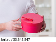 Young man with gift bag at home preparing suprise for wife. Стоковое фото, фотограф Elnur / Фотобанк Лори