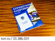 Документы работника отдела кадров:Трудовая книжка, журнал "Справочник кадровика"  лежат на столе (2019 год). Редакционное фото, фотограф Владимир Устенко / Фотобанк Лори