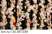 Vertically hanging garlands of popcorn for sports and movie news. On background dynamic gold background in shining lights and sparkling particles. 4K close up video. Стоковое видео, видеограф Dmitry Domashenko / Фотобанк Лори