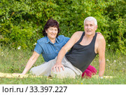 Mature beautiful couple in love on a green lawn in a park on a summer sunny day. Стоковое фото, фотограф Акиньшин Владимир / Фотобанк Лори