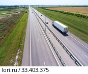 White semi trailer truck driving on wide straight highway in agricultural fields. View from above. The Don M4 route in Russia. Стоковое фото, фотограф Кекяляйнен Андрей / Фотобанк Лори