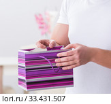 Young man with gift bag at home preparing suprise for wife. Стоковое фото, фотограф Elnur / Фотобанк Лори