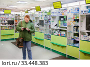 Покупательница в аптеке считает деньги (2020 год). Редакционное фото, фотограф Victoria Demidova / Фотобанк Лори