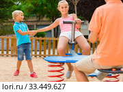 children are teetering on the swing in the playground. Стоковое фото, фотограф Яков Филимонов / Фотобанк Лори