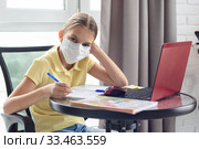 Девочка дистанционно учится в школе, отвлеклась и посмотрела в кадр. Стоковое фото, фотограф Иванов Алексей / Фотобанк Лори