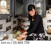 Счастливая женщина готовит еду на кухне (2020 год). Редакционное фото, фотограф Игорь Низов / Фотобанк Лори
