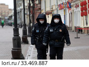 Полицейские в защитных масках патрулируют на улице Арбат в центре города Москвы во время эпидемии коронавируса COVID-19 в России (2020 год). Редакционное фото, фотограф Николай Винокуров / Фотобанк Лори
