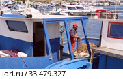debonair fisherman unravels the net, standing on a fishing boat in the port (2019 год). Редакционное видео, видеограф Ирина Мойсеева / Фотобанк Лори