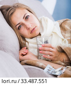 Sick girl on sofa taking drugs. Стоковое фото, фотограф Яков Филимонов / Фотобанк Лори