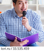 Funny man singing songs in karaoke at home. Стоковое фото, фотограф Elnur / Фотобанк Лори
