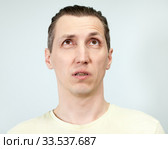 Взрослый человек что-то вспоминает, взгляд вверх, приоткрытый рот. Стоковое фото, фотограф Кекяляйнен Андрей / Фотобанк Лори