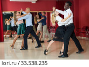 Positive adult couples dancing tango together in modern studio. Стоковое фото, фотограф Яков Филимонов / Фотобанк Лори
