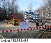 Огороженная полосатой лентой детская площадка во дворе жилых домов на Сахалинской улице в дни самоизоляции при коронавирусе Covid-19. Район Гольяново. Город Москва. Россия (2020 год). Редакционное фото, фотограф lana1501 / Фотобанк Лори